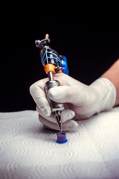 a person in white gloves is holding a small metal object with a screwdriver on it