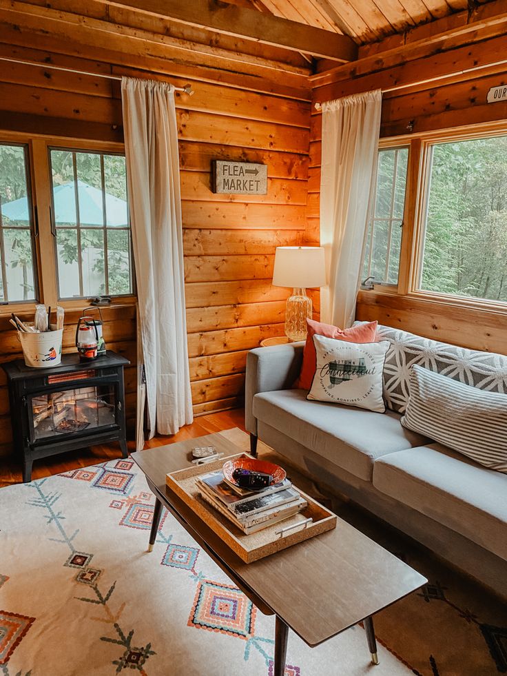 a living room filled with furniture and wooden walls