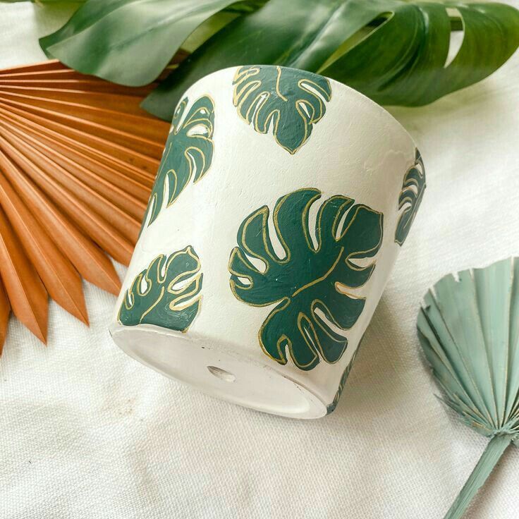 a close up of a paper cup on a table with leaves and other items around it