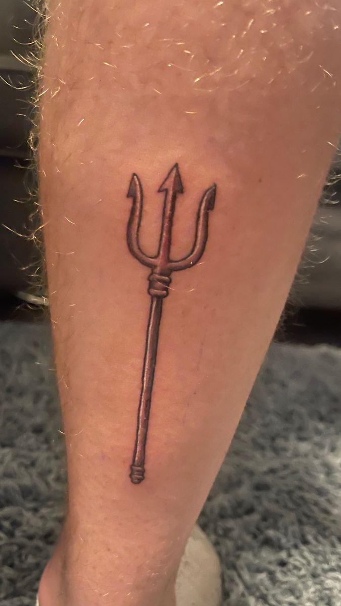 a tattoo on the leg of a person with an arrow in it's center