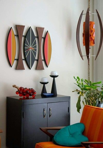 a living room filled with furniture next to a wall mounted art piece on the wall