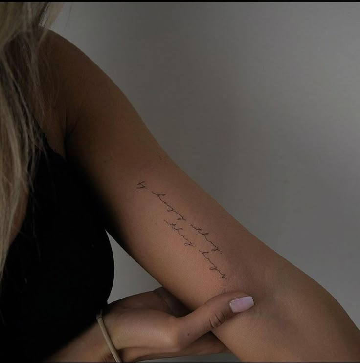 a woman holding her arm with writing on it