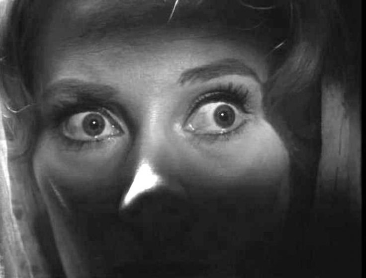 a woman's face is shown in black and white with the eyes wide open