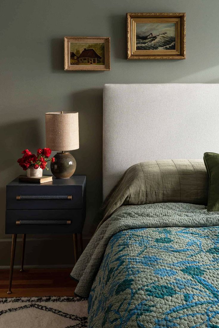 a bedroom with a bed, nightstand and two pictures on the wall above it's headboard