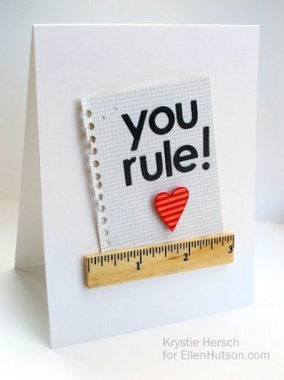 a close up of a card with a tape measure and a red heart on it