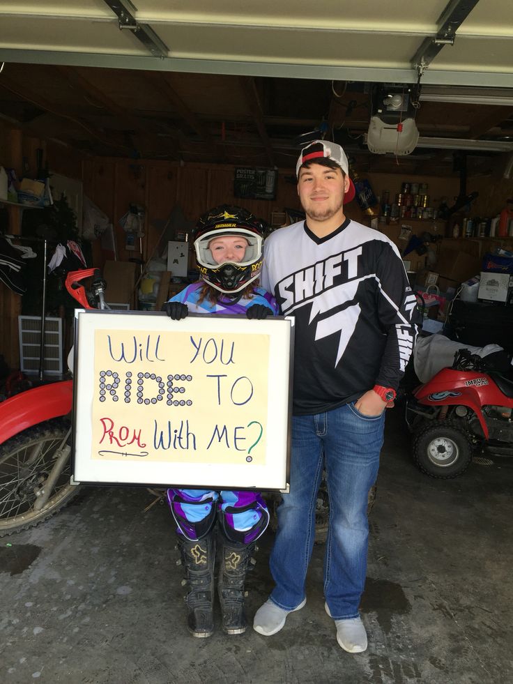 two people standing next to each other holding a sign that says, will you ride to rou with me?