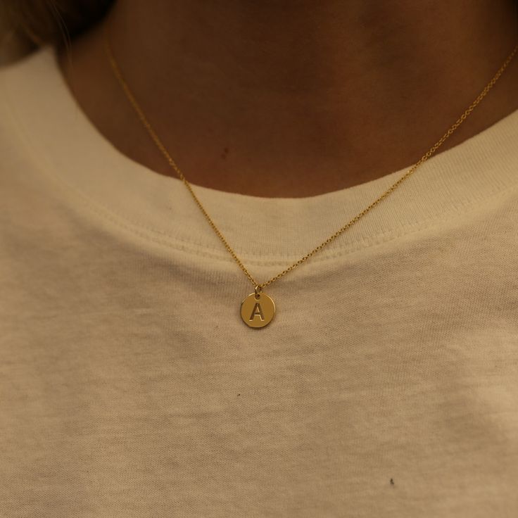 DETAILS Metal - available in 14k yellow, white, or rose gold Chain length - 16-18" Available in initials A-Z WHY WE LOVE IT Wear your favorite initial with this personalized pendant. We love this simple 14k yellow gold disc pendant necklace, with a stenciled block letter look to represent your favorite initial. This is a great giftable piece that anyone would love and wear! SHIPPING + RETURNS This item is made-to-order, please allow 4-6 weeks for production and shipping. Learn about our Return + E Pendant Necklace, L Pendant Necklace, Initial Pendant Necklace Gold, Initial Necklace Gold Letters Pendants, Necklace Initial Letter Aesthetic, Minimalist Gold Pendant, Gold Necklace With Initials, Gold R Necklace, A Initial Pendant