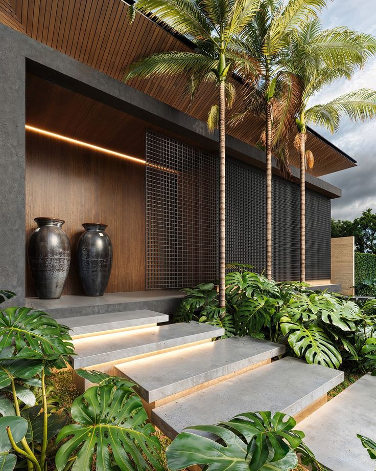 two large vases sitting on top of steps next to plants