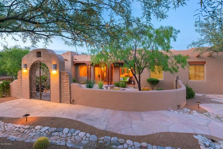 an adobe - style home in the desert at dusk