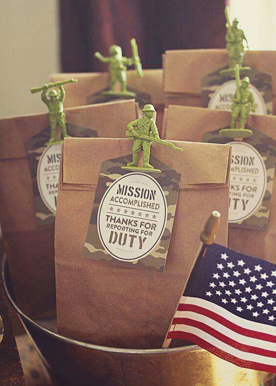 some little army figurines are sitting in a bag on a table next to an american flag