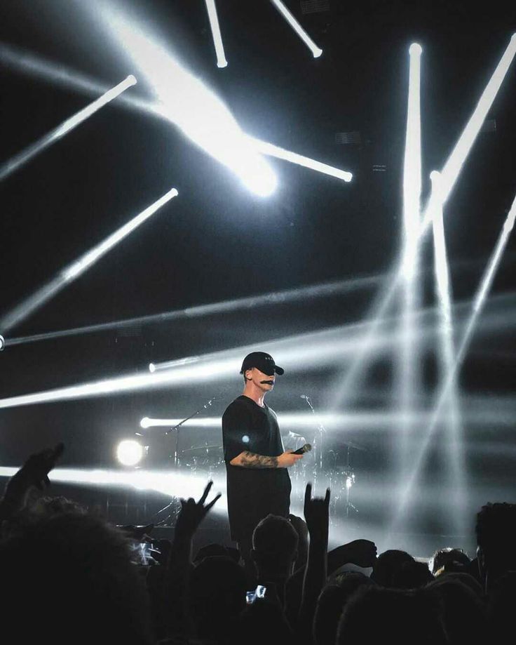 a man standing on top of a stage surrounded by lights