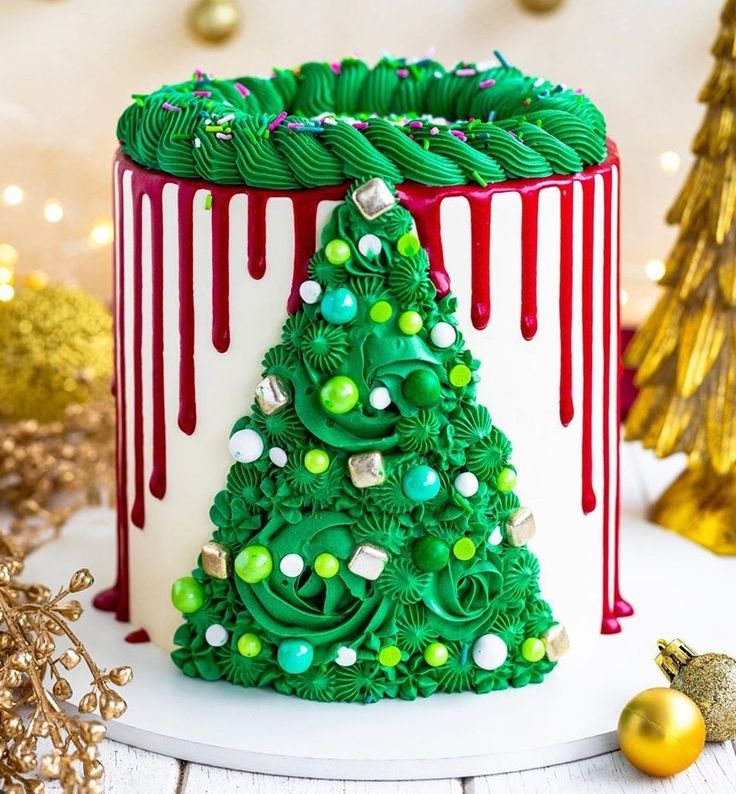 a decorated christmas tree cake sitting on top of a white plate with red and green icing