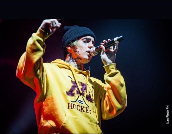 a male in a yellow hoodie is holding a microphone