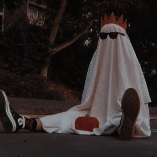 a person laying on the ground in front of a white blanket with a crown on it