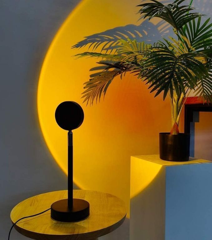 a table with a lamp on it next to a potted plant