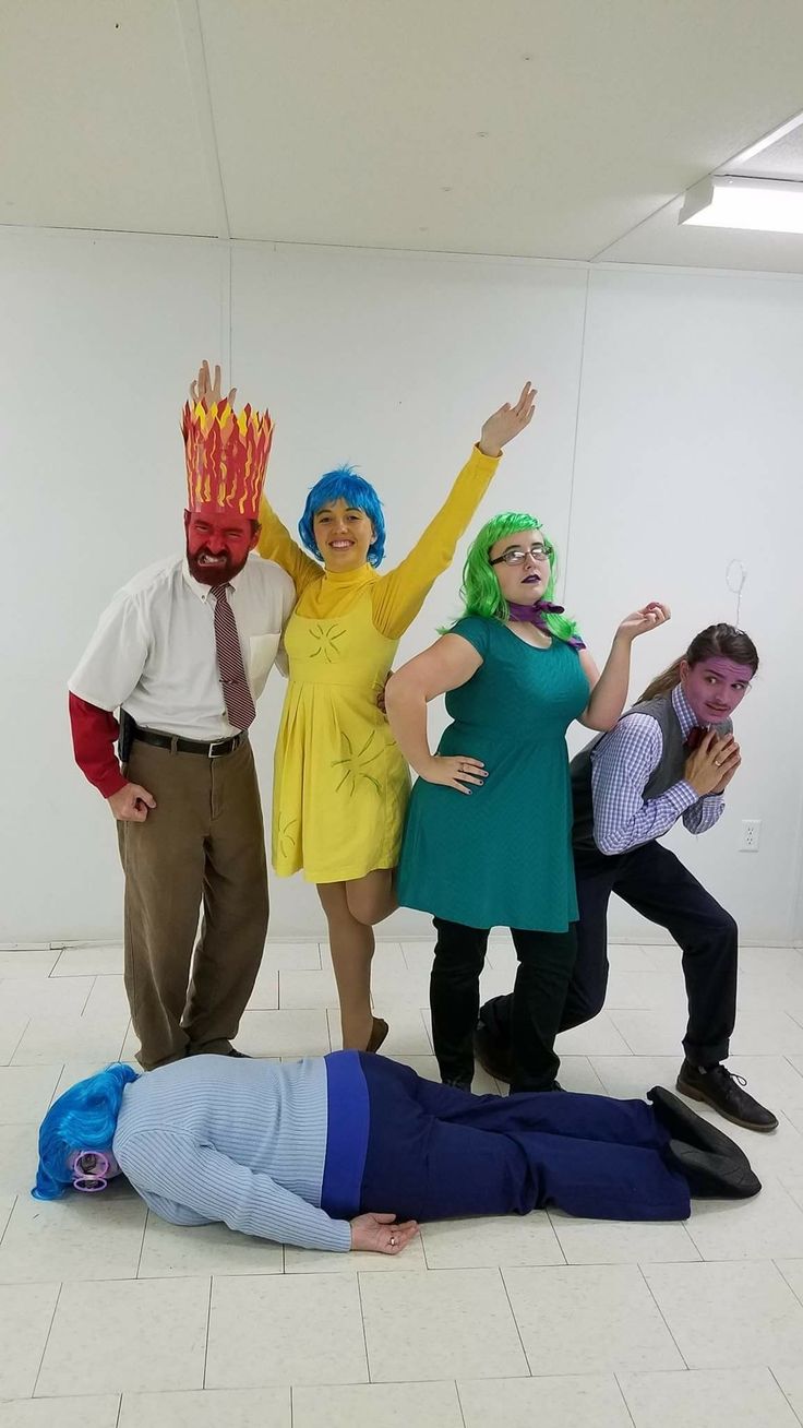 four people dressed in costumes posing for a photo with one person laying on the ground