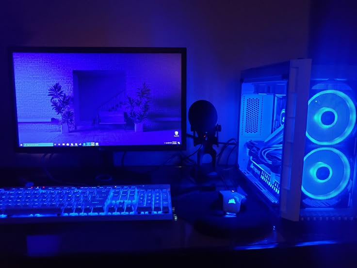 a desktop computer sitting on top of a desk next to a keyboard and monitor in a dark room