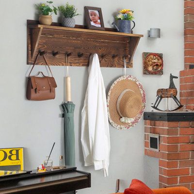 a living room filled with furniture and a fire place next to a brick wall covered in pictures