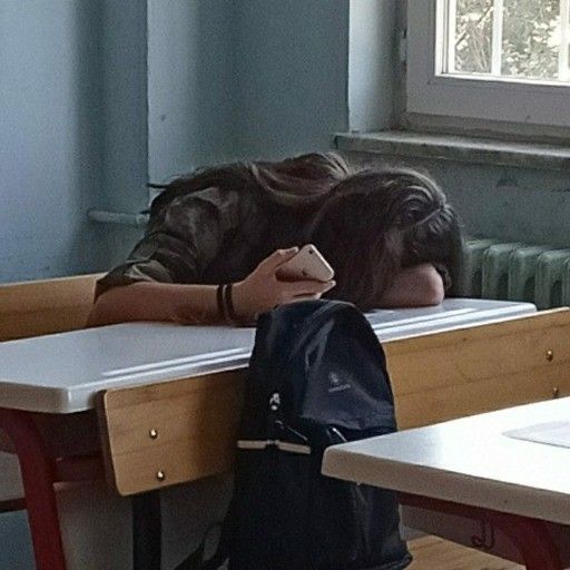 a person sleeping on a bench in a classroom