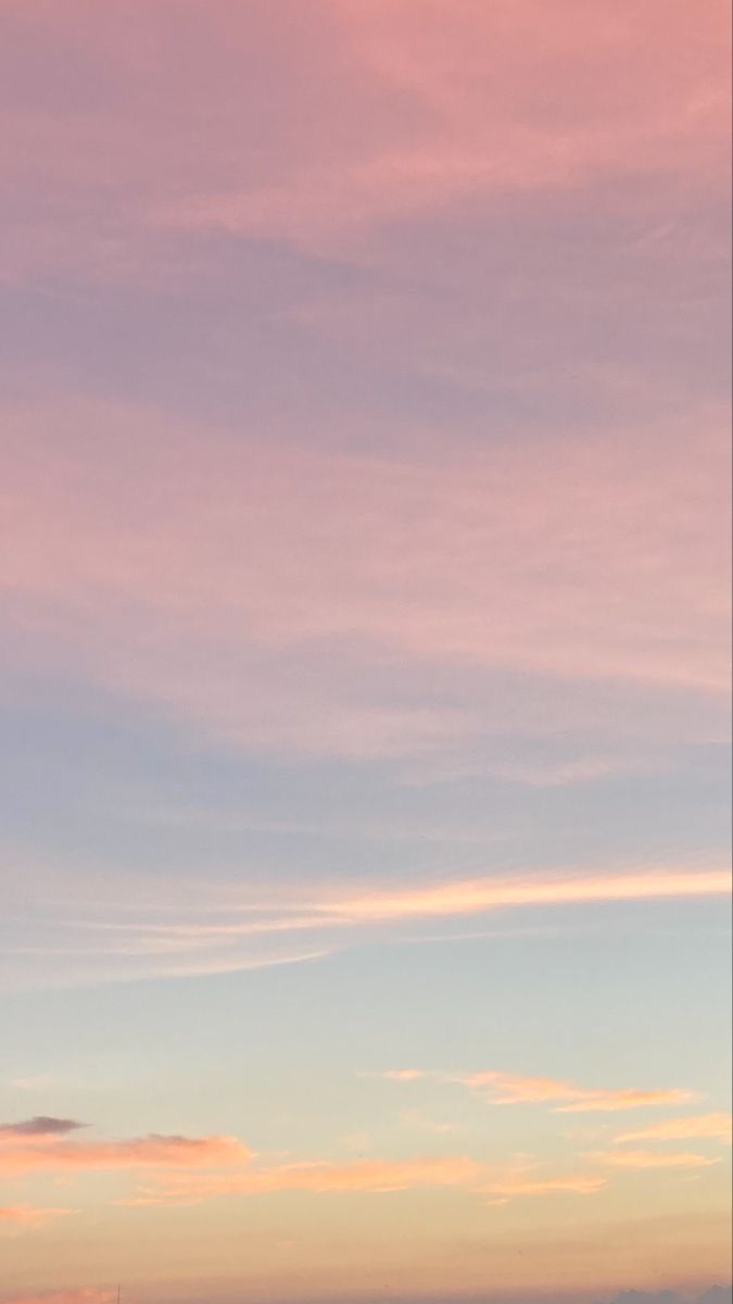 two people standing on the beach with surfboards in their hands, watching the sunset