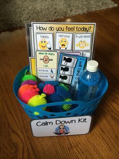 a blue bucket filled with toys on top of a wooden table next to a sign that says, how do you feel today?