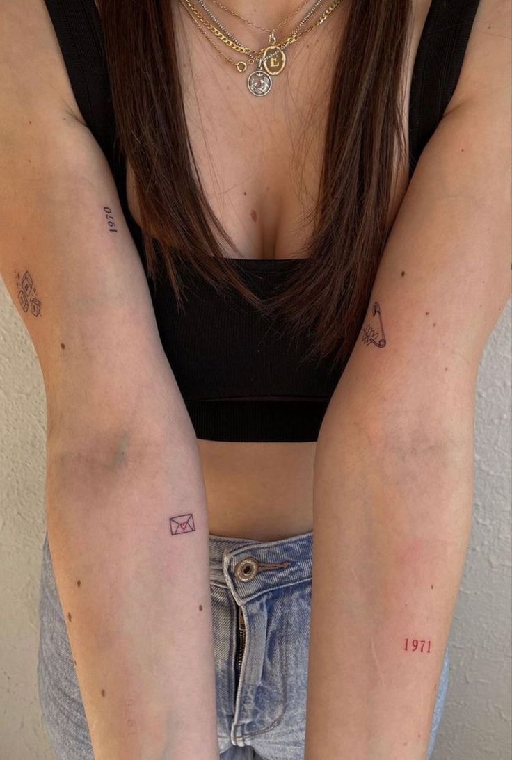 a woman with two tattoos on her arms and one arm behind her is holding the other arm