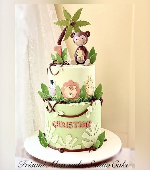 a three tiered cake decorated with monkeys on top and jungle animals on the bottom