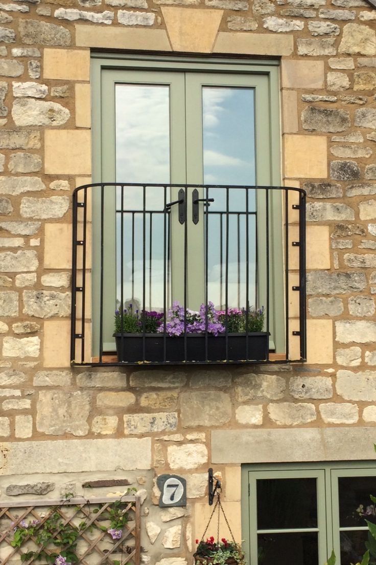 the window is open and there are flowers in the windowsills on the side of the building