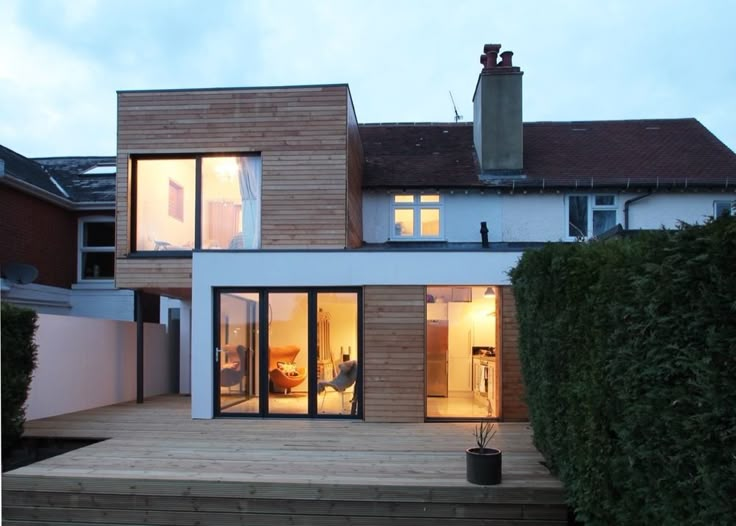 a modern house with large windows and wooden steps leading up to the front door area