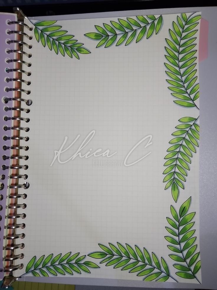 an open notebook with green leaves on it