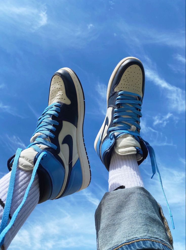 a person's feet with blue and white sneakers