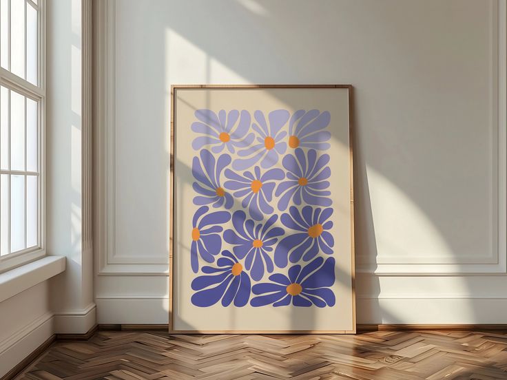 a blue and yellow flower print on a white wall in an empty room with wood flooring