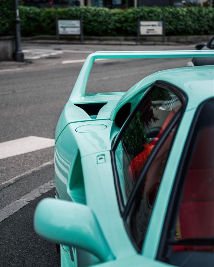 a blue sports car parked on the side of the road