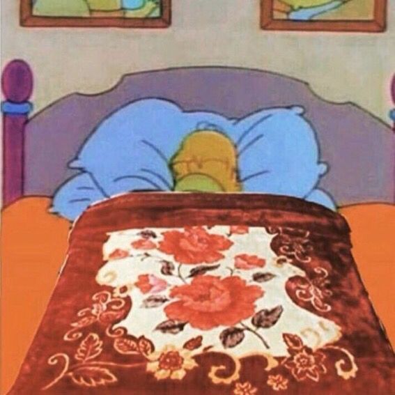 a bed with a red bedspread and two pictures on the wall above it