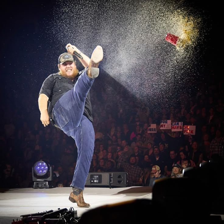 a man in black shirt and blue pants doing a trick on stage