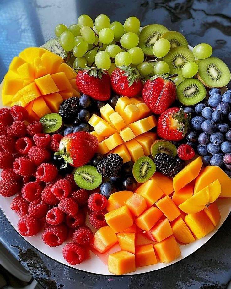 a white plate topped with lots of different types of fruit on top of a table