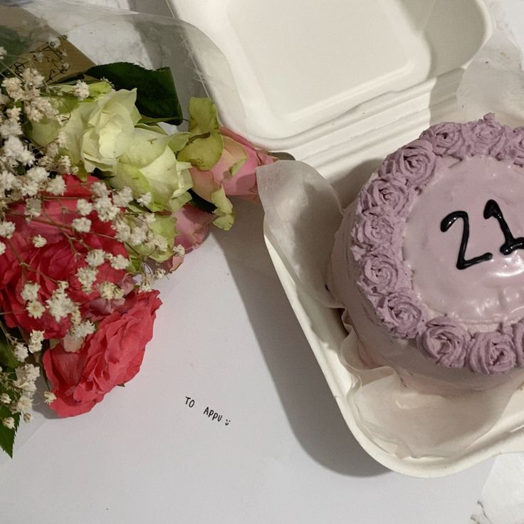 there is a cake with the number twenty on it and some flowers in front of it