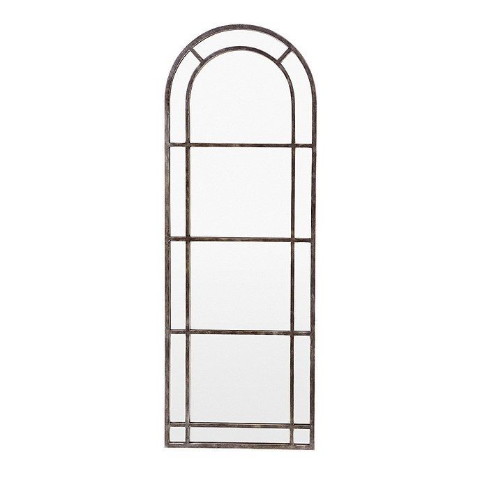 a tall metal window frame with an arched design on the top and bottom, against a white background