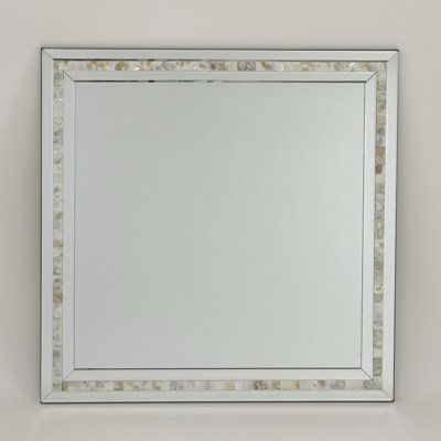 a white framed mirror sitting on top of a wall