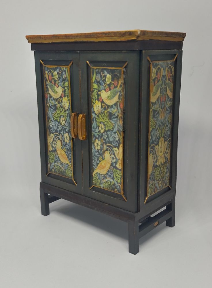 an ornate cabinet with birds and flowers painted on the doors is shown against a gray background