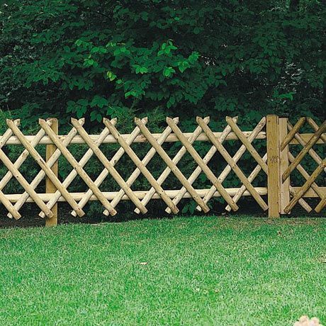 a wooden fence in the middle of some grass