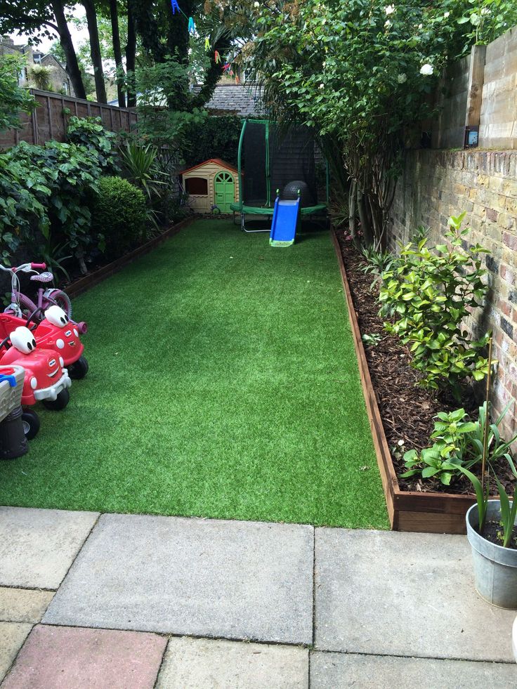 a small backyard with grass and toys in it