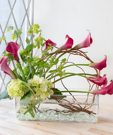 a vase filled with flowers on top of a wooden table