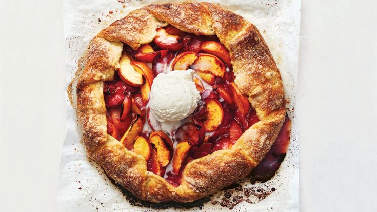 an apple pie with ice cream on top is sitting on wax paper and sits on a white surface