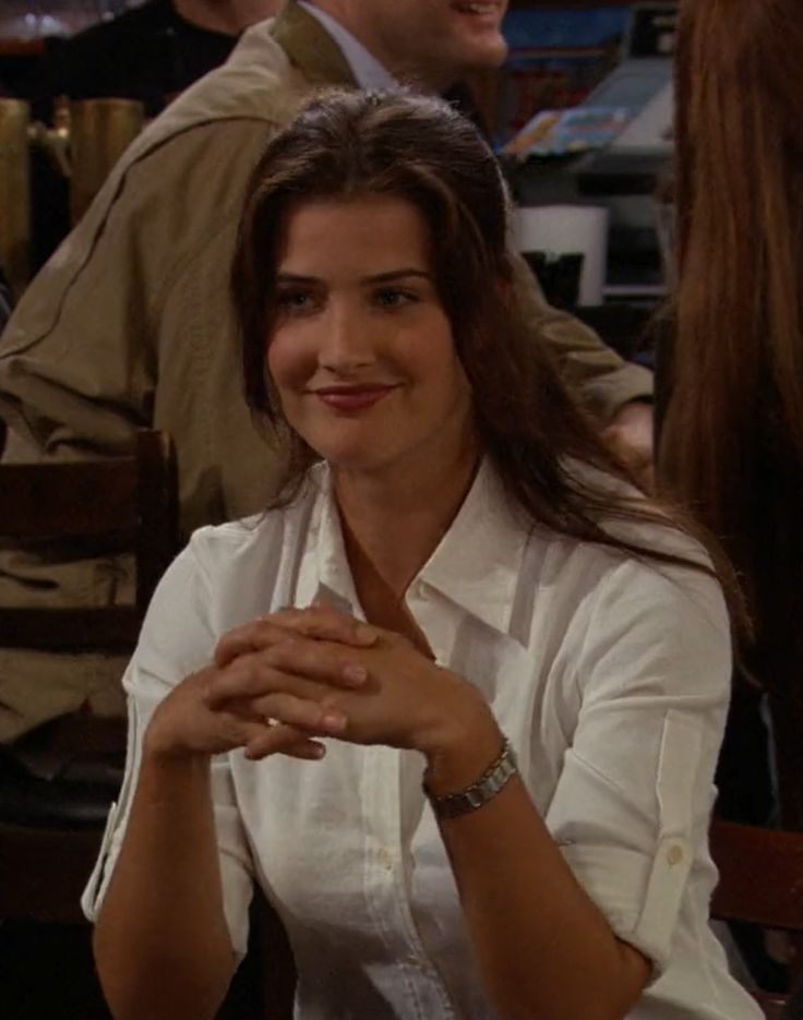 a woman sitting at a table smiling for the camera