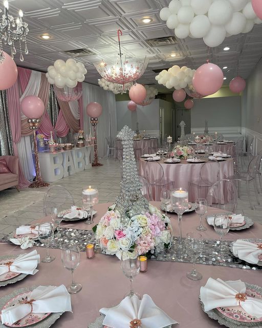 a table set up for a party with pink and white decorations