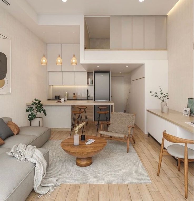 a living room filled with furniture next to a kitchen and dining room table on top of a hard wood floor