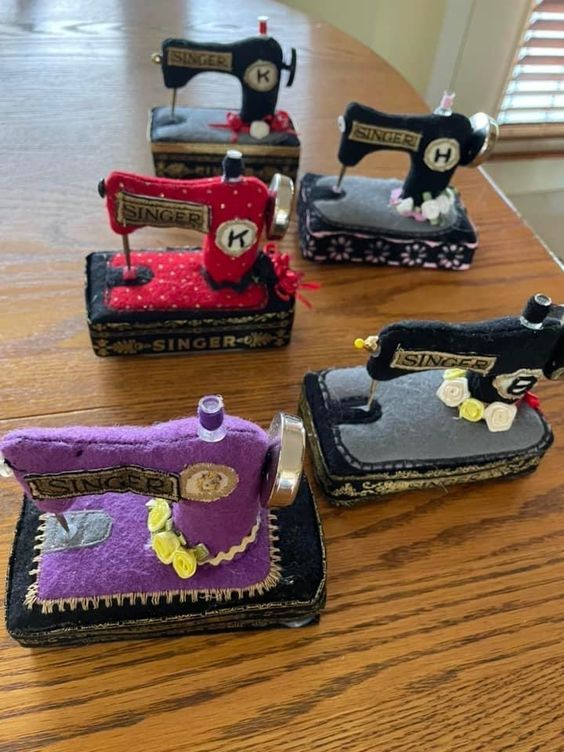 four sewing machines sitting on top of a wooden table