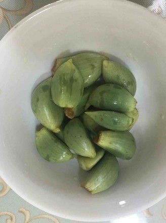 a white bowl filled with green fruit on top of a table