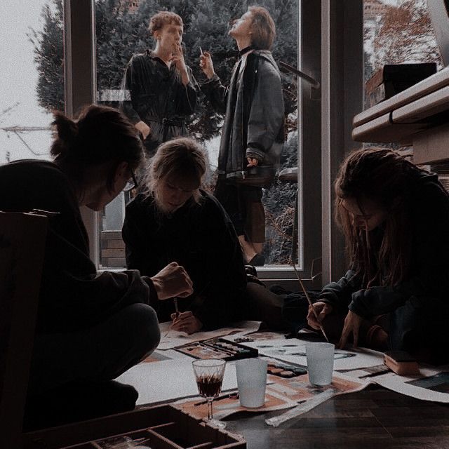 a group of people sitting around a table with papers and pens in front of them